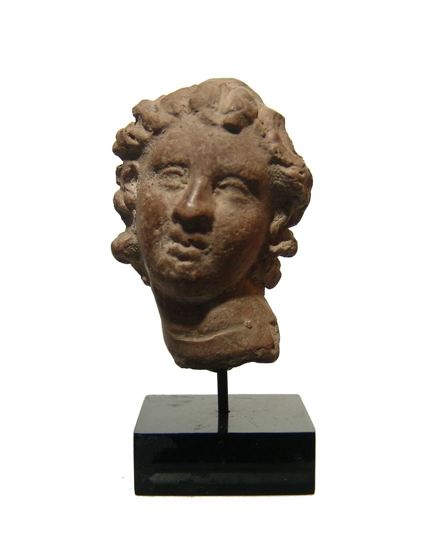 A beautiful Hellenistic terracotta head of a woman: A beautiful Hellenistic terracotta head of a woman, c. 3rd - 2nd Century BC, probably from a Northern Greek workshop. H: 2 in (5.1cm). Ex French private collection acquired in the 1960's; Royal Athena