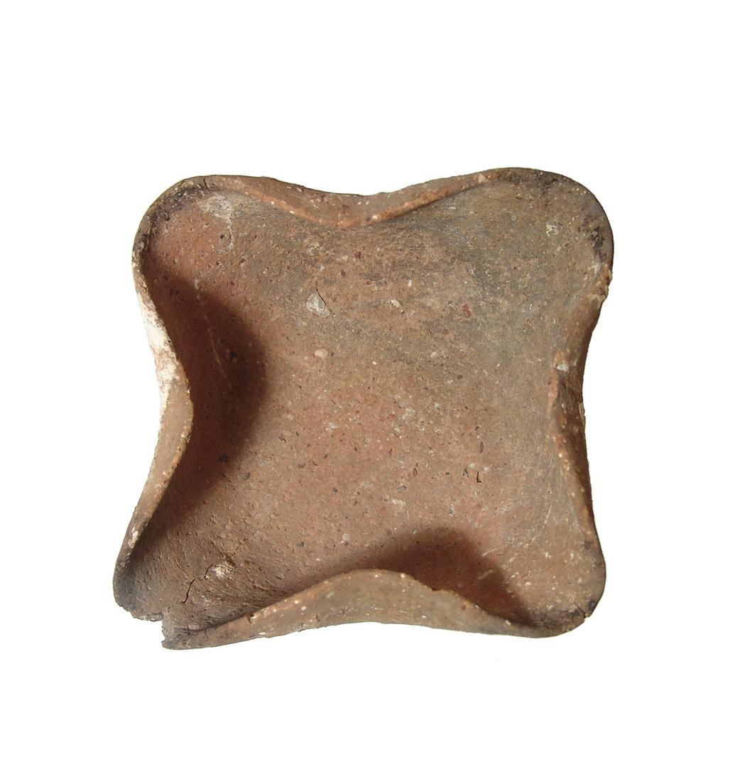 A Bronze Age four-spouted ceramic lamp: A Bronze Age four-spouted ceramic lamp, Holy Land, c. 2250 - 2000 BC, with wide, flat base and carbon deposits from heavy use. W: 4 7/8 in (12.3 cm). Moderate surface deposits. Ex Baron collection, So