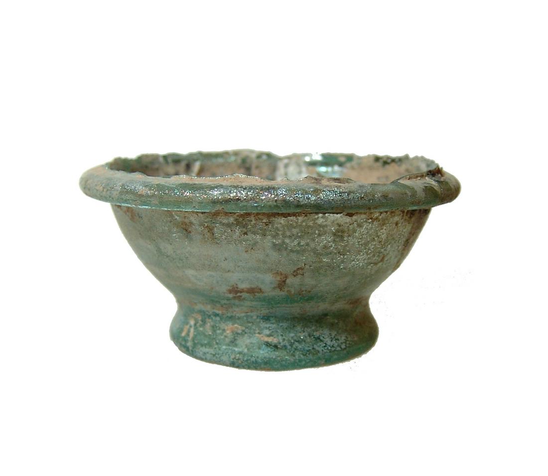 A cute Roman glass fragment: A cute Roman glass fragment that has taken the appearance of a small cup, c. 1st - 2nd Century AD, , with narrow foot and rounded rim, the surfaces with lovely iridescence amidst moderate deposits. 1