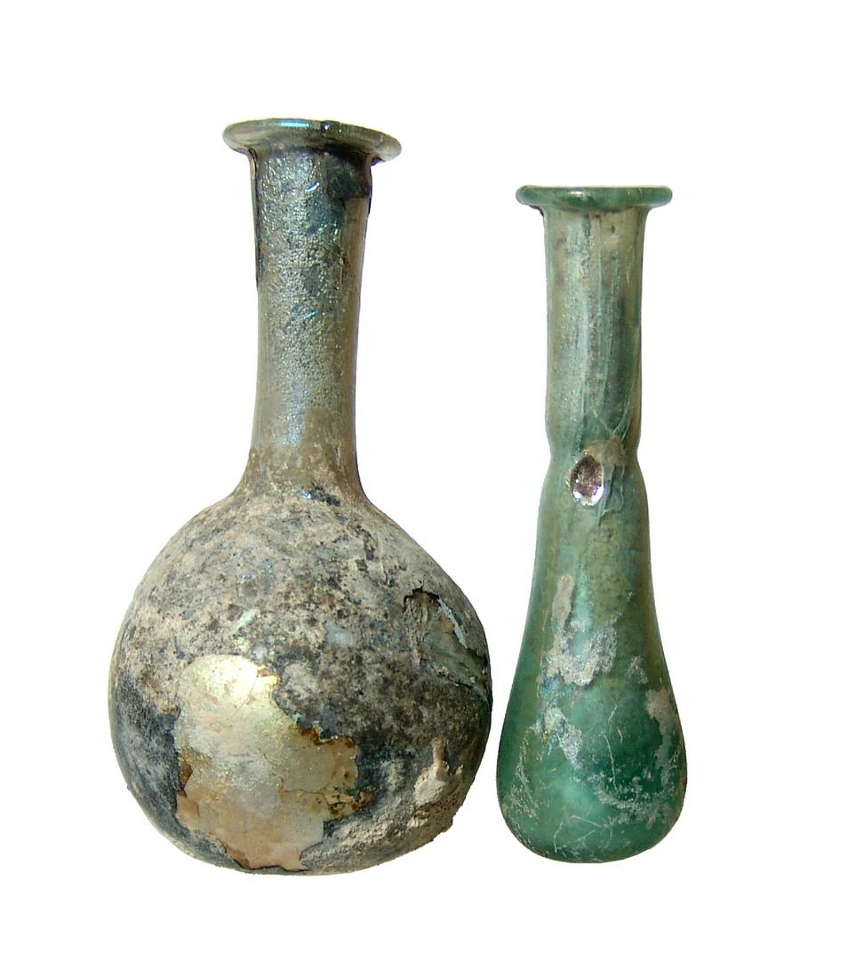 A nice pair of Roman glass bottles: A nice pair of Roman glass bottles, 1st - 2nd Century AD. Lot includes a pale green unguent bottle with constricted neck and flared mouth, H: 3 1/2 in (8.9 cm). The second is a near colorless glass bo