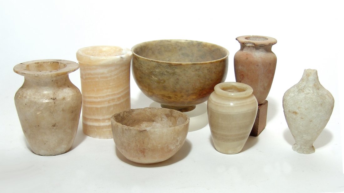 7 Egyptian/Near Eastern-style alabaster replica vessels: A group of 7 Egyptian and Near Eastern-style alabaster replica vessels. Lot includes a nice mix of types, several carved out of very attractive stone. Largest 5 3.4 x 3 3/8 in (14.6 x 8.6 cm).