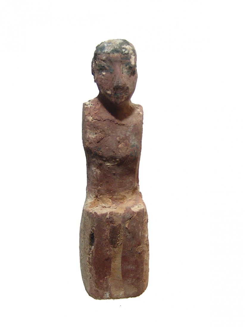 A nice Egyptian painted wood figure, Middle Kingdom: A nice Egyptian painted wood figure, Middle Kingdom, c. 2061 - 1690 BC, from a large model wood boat, depicted seated wearing a kilt and with carved faces and black wig and cosmetic details. H: 4 &fra