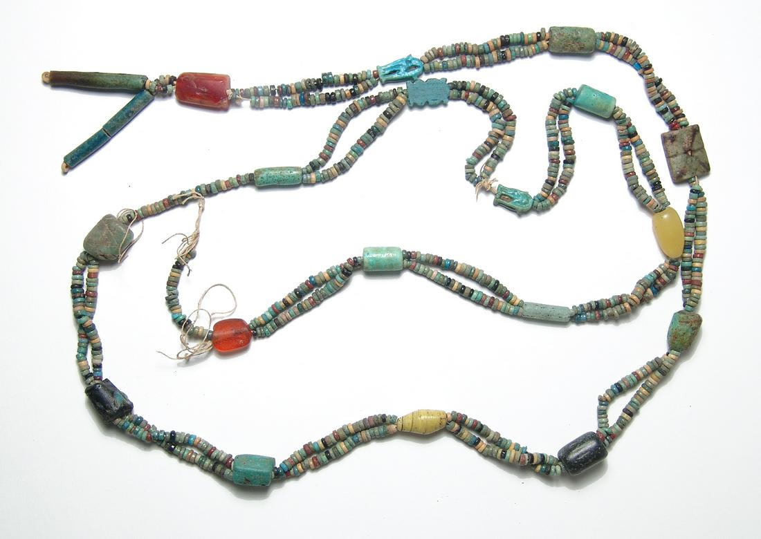 A huge strand of primarily Egyptian faience beads: A huge strand of primarily Egyptian faience beads. The high quality Egyptian multi-colored faience disk beads are strung with several Egyptian faience amulets featuring standing deities, a faience pla