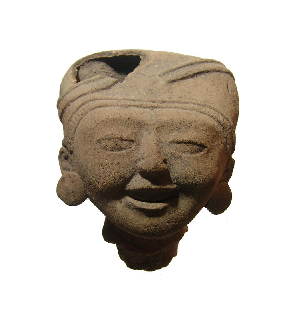 A large Vera Cruz terracotta head of a man, Remojadas: A large Vera Cruz terracotta head of a man, Remojadas, Late Classic, c. AD 550 - 940, mold-made with smiling features and wearing a headdress and ear spools. 6 3/4 x 5 in (17.2 x 12.7 cm). Minor losse