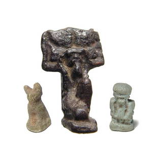 A lot of 3 Egyptian faience amulets, Late Period: A lot of 3 Egyptian faience amulets, Late Period, c. 664 - 30 BC, including an amulet of Shu, the sky god, glaze now a purplish-black, and two smaller examples depicting Pataikos and a seated cat