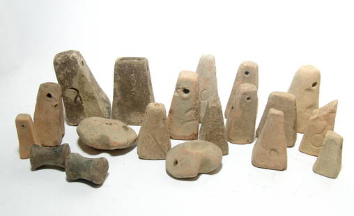 A group of 19 Greek terracotta loom weights: A group of 19 Greek terracotta loom weights, c. 5th - 1st Century BC, the balance are of pyramidal type with incised symbols on a few. Also included are two spool-shaped examples and two irregular