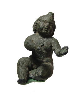 A lovely Roman bronze figure of a seated putti: A lovely Roman bronze figure of a seated putti, 1st - 2nd Century AD, the cherubic youth depicted nude with rounded features, his hair knotted at forehead and flow in curled locks. His gaze is