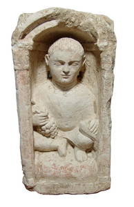 Large Coptic limestone funerary stela depicting a youth