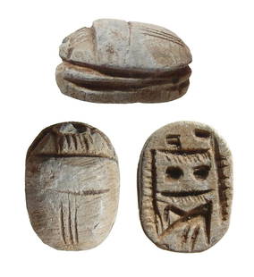 An Egyptian steatite scarab, Late Period: An Egyptian steatite scarab, Late Period, c. 664 - 332 BC, the body with triple lines dividing the shell and multiple lines on the head, legs grooved. On base a dedication to Amen-Re with a Horus falc