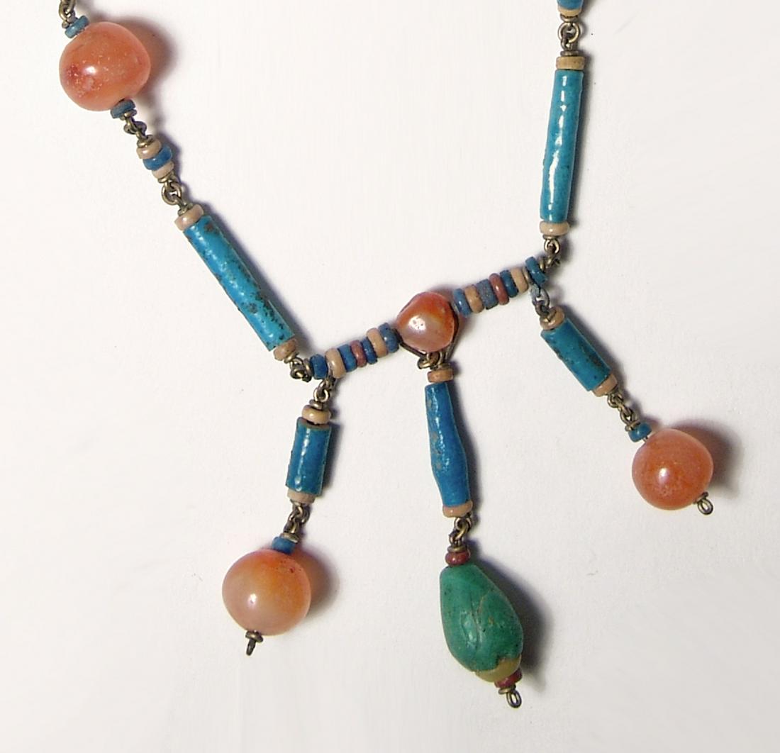 Gorgeous Egyptian necklace of faience, glass, & stone: A gorgeous necklace comprised of Egyptian faience, glass, and stone beads. The beads include well-preserved Late Period faience tube and disc beads, c. 664 - 332 BC, a Roman green glass pendant bead, 