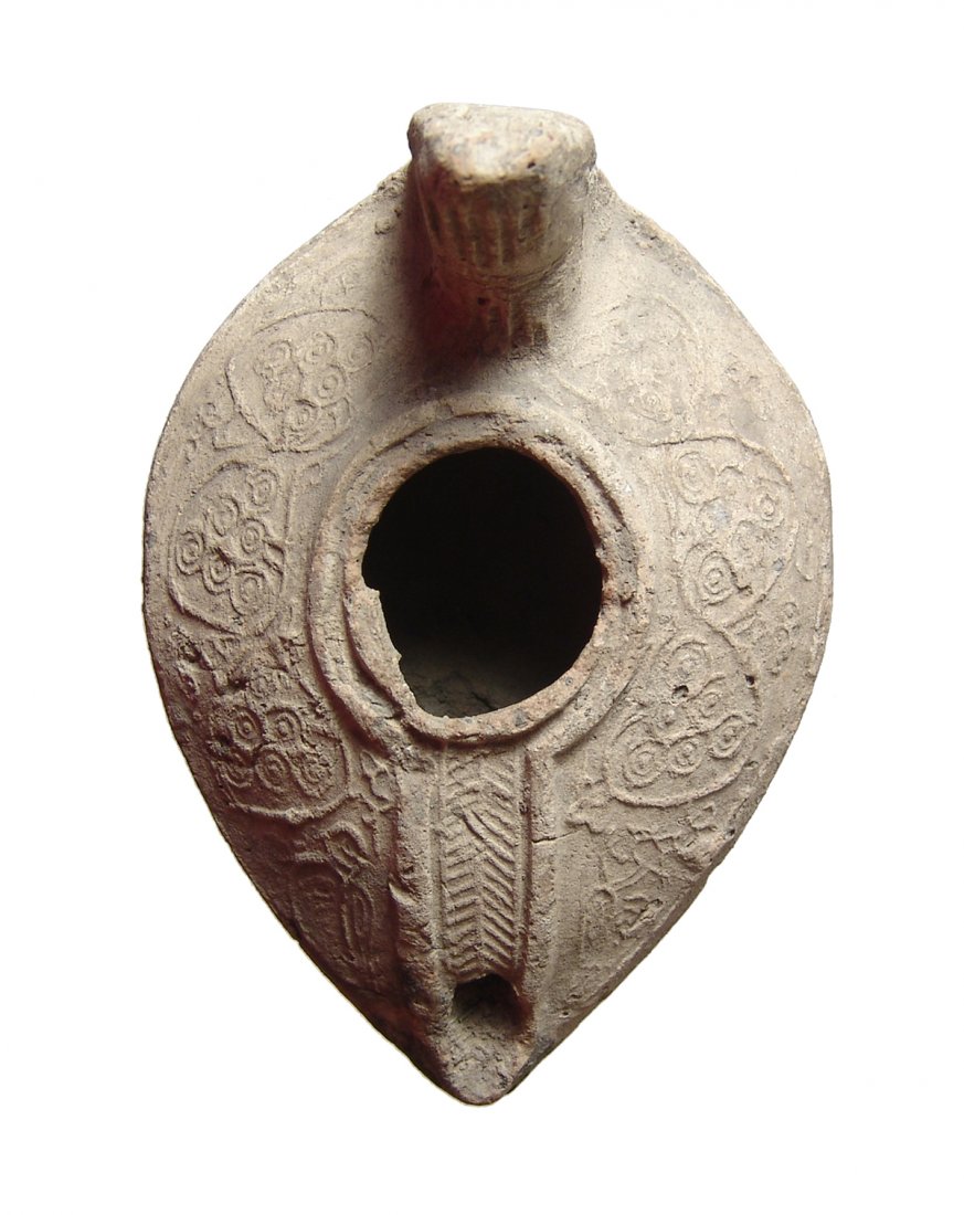 A beautiful Islamic ceramic lamp, Holy Land: A beautiful Islamic ceramic lamp, Holy Land, 7th - 8th Century AD, the body ovoid with lovely molded floral decoration on the shoulders, the fill-hole bordered by a ridge and low channel which connect