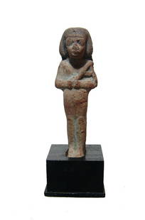 A nice Egyptian terracotta ushabti, Dynasty 21: A nice Egyptian terracotta ushabti, 3rd Intermediate Period, Dynasty 21, c. 1075 - 945 BC, well-molded with good detail, depicted mummiform, wearing short wig, arms folded at chest and holding a hoe,