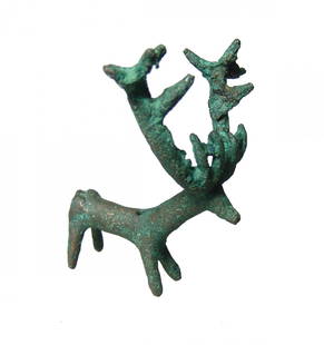 Near Eastern bronze figure of a deer with large antlers: A Near Eastern bronze figure of a deer with large antlers, c. 1200 - 800 BC, the body cylindrical with tapered legs and short tail, the head simplified with large elaborate antlers. H: 3 in (7.6cm),