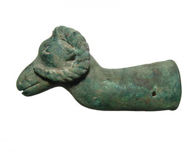 Near Eastern bronze protome in ram: A Near Eastern bronze protome in the form of highly detailed ram's head, c. 1000 - 600, face and curled horns nicely detailed the mounting shaft flared with two holes for rivets or pins. L: 8 in