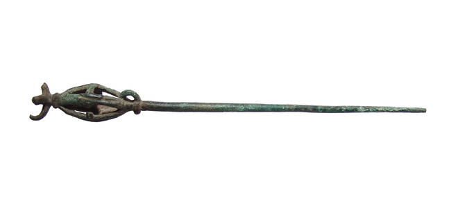 A nice Near Eastern bronze pin: A nice Near Eastern bronze pin, c. 1200 - 600 BC, terminating in a cage-like feature, topped with what was likely a bird, small loop at side. L: 9 1/2 in (24.2 cm). Nicely patinated. Ex West Virginia