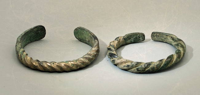 A matching pair of Near Eastern bronze bracelets: A matching pair of Near Eastern bronze bracelets, c. 800 - 200 BC, most likely made for a child with flattened terminals decorated with incised linear decor. Dia: 1 7/8 in (4.8 cm) & 1 3/4 in (6.9