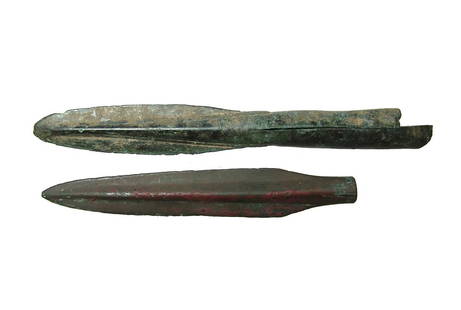 A pair of bronze javelin points: A pair of bronze javelin points. The first is an early Greek type, c. 1200 - 800 BC, with narrow tongue-like blade possessing a blunted tip and fissured tube, L: 6 1/2 in (16.4 cm). The second is a