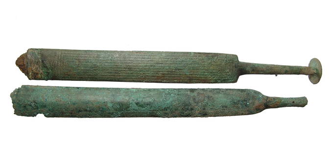 A rare pair of Villanovan bronze scabbards/sheaths: A rare pair of Villanovan bronze scabbards/sheaths, 9th - 8th Century BC, one with the remnants of an iron sword. Each is formed from sheet bronze decorated with raised linear designs, one with a