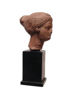 A lovely Greek ceramic head of a lady: A lovely Greek ceramic head of a lady, c. 4th Century BC, with beautifully rendered features, her hair styled back to a large coiled bun at the back of her head. H: 2 1/8 in (5.4 cm). Light deposits