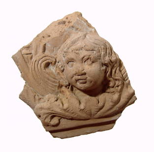 Lovely Roman terracotta antefix depicting Eros: A lovely Roman terracotta antefix depicting Eros, c. 1st - 2nd Century AD, his youthful head with rounded features and long curly hair, the head sits amidst acanthus leaves and was part of a larger