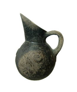 A nice Yortan ovoid black-ware vessel: A nice Yortan black-ware vessel from Anatolia, Early Bronze Age II, c. 2700 - 2400 BC, the ovoid body with narrow flattened base, the flared mouth angled sharply for pouring with a single loop