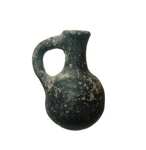 An attractive black ware juglet, Holy Land: An attractive black ware juglet, Holy Land, c. 1000 - 600 BC, Iron Age II, the body rounded with narrow neck, flared mouth and loop handle. H: 3 1/2 in (8.9 cm). in nice condition with surface