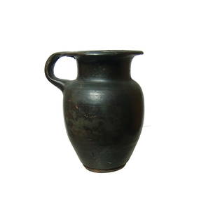 A pleasing Greek black-glazed olpe, Magnia Graecia: A pleasing Greek black-glazed olpe, Magnia Graecia, 4th Century BC, the body ovoid with flat base, the neck short with flared mouth and single handle. H: 3 3/4 in (9.5 cm). Attractive glossy black