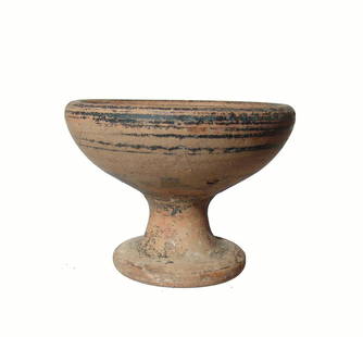 A Greek black-glazed pedestal bowl: A Greek black-glazed pedestal bowl, c. 4th - 3rd Century AD, banded on sides, the bowl deep with widely flared foot. 3 3/8 x 4 1/2 in (8.6 x 11.4 cm). Some surface weathering. Ex Los Angeles private