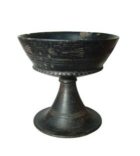 A lovely Etruscan bucchero chalice: A lovely Etruscan bucchero chalice, 6th Century BC, on flared pedestal foot adorned with incised horizontal bands, the bowl with steep walls and scalloped carination, the exterior decorated with