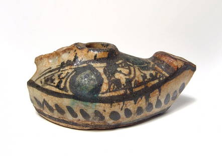 A lovely Nishapur glazed oil lamp: A lovely Nishapur glazed oil lamp, 12th Century BC, of ovoid form with flattened bottom, the sides decorated with a stylized scene in dark green and black, a band of angled dashed below. L: 5 1/5 in (