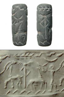 A Levantine grey steatite cylinder seal with animals: A Levantine grey steatite cylinder seal, c. 2nd Millennium BC, depicting a horned antelope and a bull flanking an emblem, a figure stands to rt. with arms raised. The scene is bordered above with a