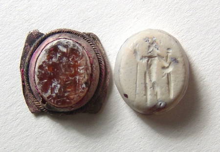 A pair of Roman chalcedony intaglios: A pair of Roman chalcedony intaglios, c. 1st - 3rd Century AD, both in carnelian, the first with a creme patina with a nicely incised image of Genius, raising hand and holding a cornucopia, 13.5 x 12