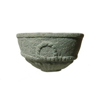 A Bactrian chlorite bowl: A Bactrian chlorite bowl, c. 1st - 3rd Century AD, beautifully carved with a rosette pattern on the bottom and three faux handles. 1 5/8 x 2 3/4 in (4.1 x 6.9 cm). Mineral deposits throughout. Ex