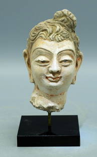 A gorgeous Gandharan stucco head: A gorgeous Gandharan stucco head, Indus Valley, c. 4th - 5th Century AD, superbly detailed and masterfully carved in stucco depicting an individual with beautifully detailed coif with topknot. H: 4