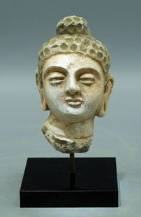 A lovely Gandharan stucco head: A lovely Gandharan stucco head, Indus Valley, c. 4th - 5th Century AD, superbly detailed and masterfully carved in stucco depicting Buddha, portrayed with a serene countenance, elongated ears with