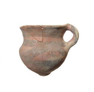 A Neolithic Chinese cup with line decoration: A Neolithic Chinese cup with line decoration, 3rd Millennium BC, with barrow pad base, flared mouth, and single loop handle. The vessel is adorned with wide lines in dark brown slip. 3 3/8 x 3 3/4 in