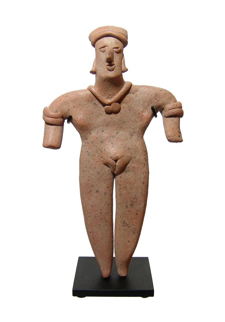 A nicely styled Colima figure of a standing woman: A nicely styled Colima figure of a standing woman, West Mexico, c. 100 BC - AD 250, depicted nude, wearing a wrapped headdress, a necklace with two circular pendants and arm bands, her features are ve