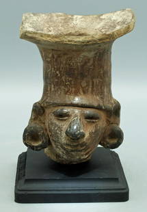 An attractive Manteno head, Ecuador: An attractive Manteno head, Ecuador, c. AD 1000 - 1500, highly burnished and depicts an individual wearing a conical headdress and large ear spools. H: 5 in (12.7 cm). Strong mineral deposits,