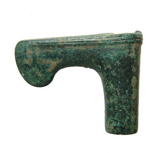 A Near Eastern bronze axe: A Near Eastern bronze axe, c. 1000 - 800 BC, with narrow shaft hole and rounded cutting edge. Ribbed bands adorn the upper edge with a central band along the top. 2 3/4 x 3 3/8 in (7 x 8.7 cm).