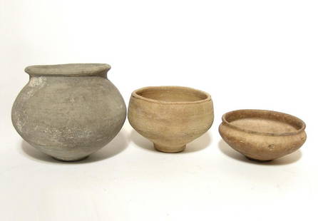 A group of 3 Roman ceramic vessels: A group of 3 Roman ceramic vessels, c. 1st - 3rd Century AD, including a grey ware jar with narrow foot and rounded rim, H: 4 3/4 in (12 cm), and a pair of creme ware bowls, Dia: 4 5/8 in (11.7 cm)