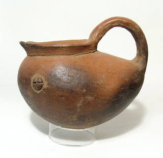 A Nicoya monochrome shoe pot, Costa Rica: A Nicoya monochrome shoe pot, Costa Rica, AD 1200 - 1550, with little applique hallucinogenic buttons/adornos on either side and a small zoomorphic applique at the back. Attractive black/orange