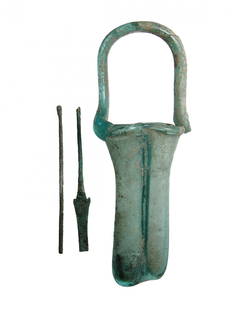 A nice Roman blue-green glass double unguentarium: A nice Roman blue-green glass double unguentarium, c. 4th Century AD, comprised of two conjoined tubes with rounded rims and tall loop handle. Within are two bronze applicators, one a spatula and the