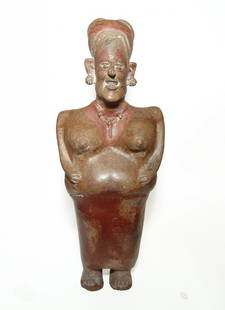 A huge Jalisco ceramic figure of a woman, West Mexico: A huge Jalisco ceramic figure of a woman, West Mexico, c. 100 BC - AD 250, with lovely glossy surface and a lively expression. She is depicted standing wearing a close fitting dress, with her breasts