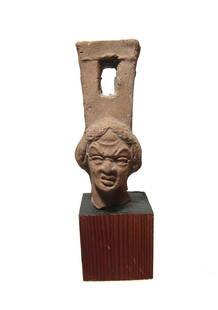 Roman ceramic sistrum handle with female grotesque: A choice Roman ceramic sistrum handle with head of female grotesque, Egypt, 1st - 2nd Century AD, with fantastic detail and with expressive features, the rectangular attachment atop her head pierced w