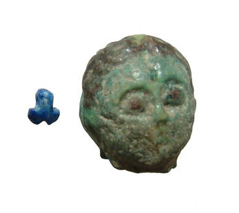 Egyptian faience head and a lapis amulet: An Egyptian faience head and a lapis amulet. Lot includes a small lapis amulet in the form of a phallus, the label describing as Mesopotamian, c. 5000 - 4000 BC, well-preserved with small suspension l