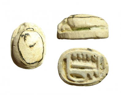 An Egyptian faience scarab, Late Period: An Egyptian faience scarab, Late Period, c. 664 - 332 BC, the base inscribed with a blessing from 'Amen-Ra'. 13 x 9 mm. Traces of green glaze, holed lengthwise for suspension. Ex Spangenberg