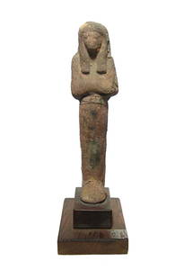 Large Egyptian terracotta ushabti, Late New Kingdom: A large Egyptian terracotta ushabti, Late New Kingdom, c. 1200 - 1075 BC, depicted mummiform, wearing tripartite wig, arms folded at chest and holding a pick and hoe. H: 7 3/4 in (19.7 cm). Traces of