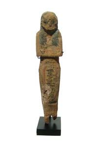 An Egyptian wooden ushabti, Late New Kingdom: An Egyptian wooden ushabti, Late New Kingdom, c. 1200 - 1075 BC, retaining much of its original pigment. The ushabti is depicted mummiform, wearing tripartite wig, arms folded at chest, hand with impl