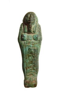 An attractive turquoise glazed ushabti, Late Period: An attractive turquoise glazed ushabti, Late Period, 664 - 332 BC, depicted mummiform, wearing tripartite headdress with false beard, hands folded at chest and holding a pick and a hoe, basket over