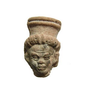 Graeco-Egyptian terracotta head in grotesque style: A detailed Graeco-Egyptian terracotta head in grotesque style, c. 2nd - 1st Century AD, wearing wreath tied with fillets surmounted a modius/polos headdress, facial features nicely detailed. H: 2 3/4
